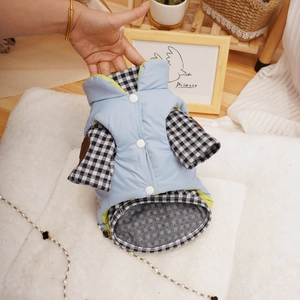 Detail of blue quilted pet vest with black and white plaid long sleeves and white buttons