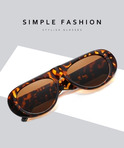 Detail of tortoise shell texture and dark brown lenses on oversized retro sunglasses
