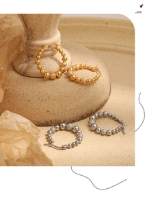 Detail of gold and silver beaded hoop earrings with mixed polished and frosted finishes