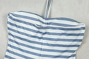 Detailed view of the halter neckline and blue striped knit fabric of the jumpsuit
