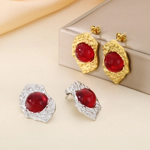 Macro shot of irregular 18K gold plated earrings with red opal and S925 silver needles