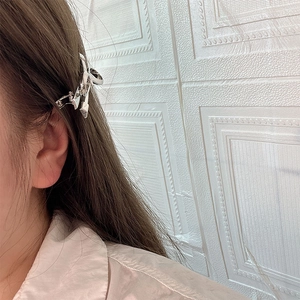 Elegant silver metal bow hair claw clip for women shown on long brown hair