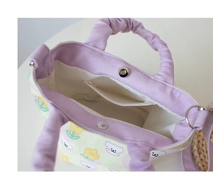 Detail of canvas bucket bag with magnetic closure, teddy bear print and ruffled handle