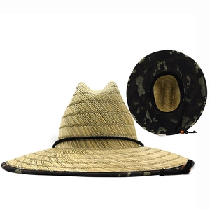 Detailed view of straw sun hat featuring a camouflage brim pattern and adjustable chin strap