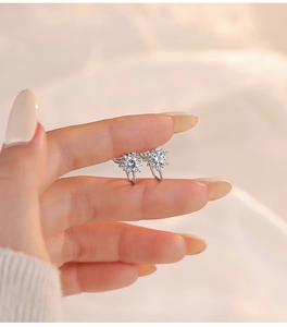 Detailed close-up of S925 sterling silver sunflower ear clips with sparkling zircon stones