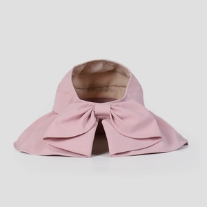 Dettaglio visiera parasole rosa con grande fiocco e design aperto per coda di cavallo