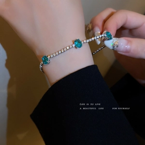 Elegant blue crystal bracelet with silver diamond-set base on wrist, luxury fashion style