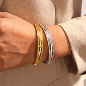 Detail of 18k gold and silver bracelets with cubic zirconia and embossed centerpiece
