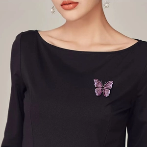 Elegant purple butterfly brooch with crystals pinned on a black dress worn by a model