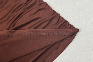 Détails de couture surjet et texture du tissu sur une robe moulante marron ajustée