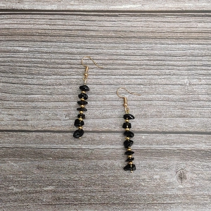 Close-up of handmade natural black crystal tassel earrings with elegant gold accents