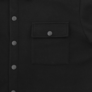 Close-up of black heavy-duty cargo jacket showing flap pocket and matte button details