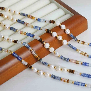 Macro shot of bohemian beads necklace with white pearls and blue gemstones