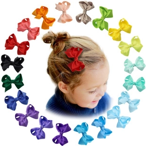 Detail showing 19 colors of ribbed ribbon bow hair clips on a child model with bun