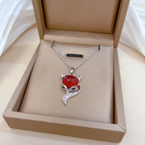 Close-up of luxury red fox pendant necklace with crystals in a beige jewelry gift box