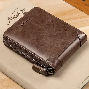 Detail of genuine crocodile leather texture and premium metal zipper on a brown wallet
