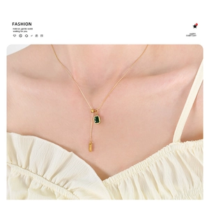 Detail of vintage emerald zircon pendant necklace with adjustable tassel on model