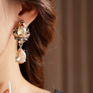Close-up of vintage drop earrings with champagne crystals on model for a retro look