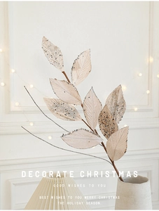 Detail of champagne glitter velvet Christmas artificial leaves in a minimalist vase