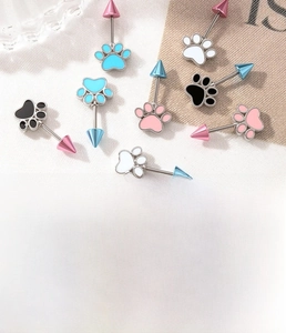 Detail showing colorful cat paw piercing studs with steel bars in blue pink and black