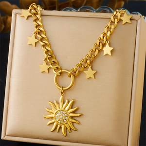 Detailed shot of golden chain necklace with star charms and sun pendant on beige stand