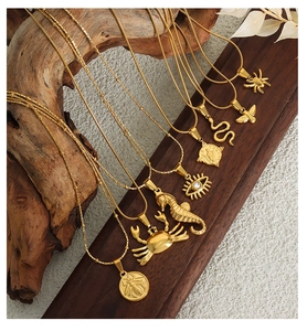 Detailed macro view of gold-plated geometric animal charms and coins on elegant chains