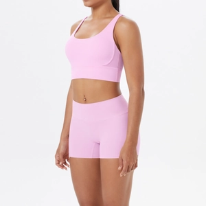 Vue détaillée d'un ensemble de yoga rose avec brassière et short taille haute sur modèle