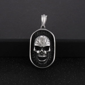 Macro shot of silver punk skull pendant with vintage embossed detail and antique finish