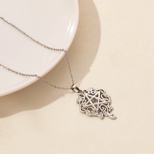 Macro shot of silver star pendant with intricate hollow vine patterns and fine chain link
