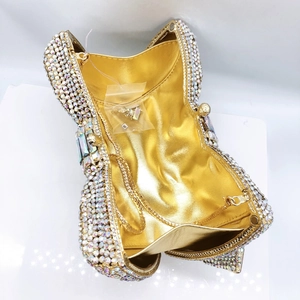 Macro shot of luxury clutch bag showing golden lining, multi-color rhinestones and chain