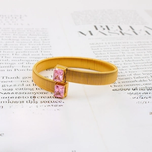 Minimalistische gouden roestvrijstalen open armband met twee roze zirkoonstenen