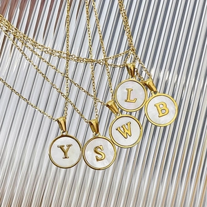 Detailed shot of 18K gold-plated stainless steel initial necklaces with pearl shell