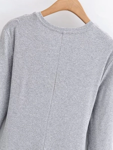 Detail of grey knitted long-sleeve top with central back seam stitch on a wooden hanger