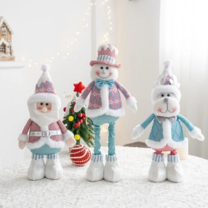 Close-up of fabric Christmas dolls with sequins and fur trim on white knit cloth