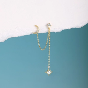 Close-up of golden S925 silver chain earrings with pavé star and moon tassel details