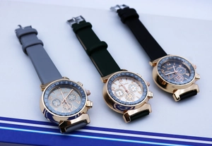 Detail of three-eye quartz watch faces with gold casing and colored silicone straps