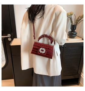 Crocodile pattern burgundy mini bag with rhinestone buckle shown on a model