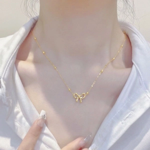 Elegant gold titanium steel necklace featuring a hollow 3D bow pendant on a bead chain