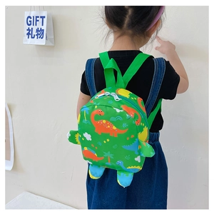 Kid back view wearing a green dinosaur print backpack against a clean wall background