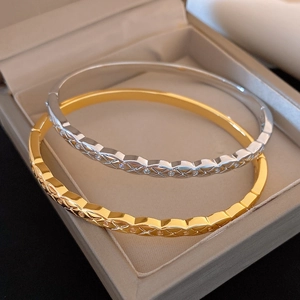 Vue détaillée de joncs en or 18k et argent avec motifs croisés et pierres serties