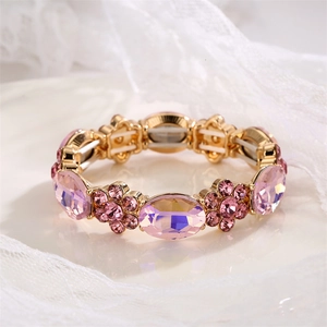 Close-up of gold stretch bracelet featuring pink oval crystals and floral crystal motifs