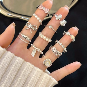 Detailed view of 10-piece 925 silver ring set with pearls, bow, and pink heart stone