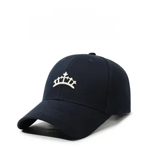 Gros plan d'une broderie couronne blanche sur une casquette de baseball bleu marine