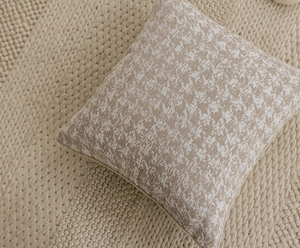 Macro detail of beige textured fabric throw pillow cover with abstract woven pattern