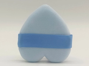 Close-up of a heart-shaped light blue velvet powder puff with a satin finger strap