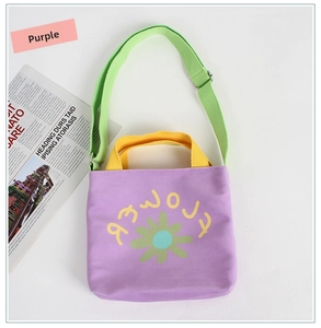 Detail of purple canvas tote bag with yellow flower print and adjustable green strap