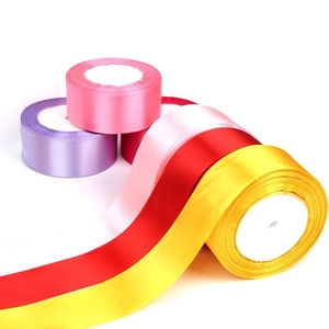 Detail view of colorful 4cm satin ribbons in pink, red and yellow for DIY gift wrapping
