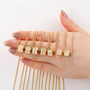 Detail of 18K gold-plated cube pendants with sparkling cubic zirconia letter charms