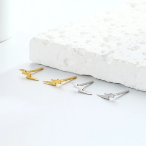 Detailed close-up of S925 sterling silver lightning bolt studs in gold and silver