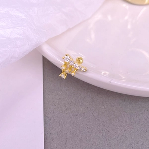 Vue macro du piercing en argent S925 doré avec chaînes pendantes et cristaux pavés